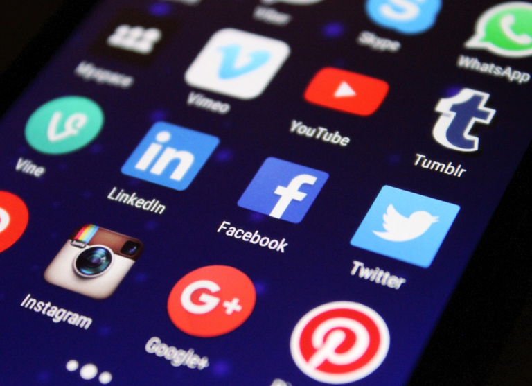 Smartphone screen with social media app icons including Facebook, Twitter, LinkedIn, Instagram, and YouTube